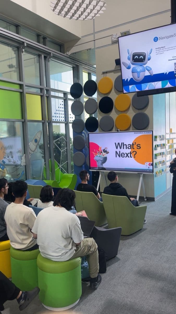 Students on colourful seats watch a screen that reads "What's Next?".